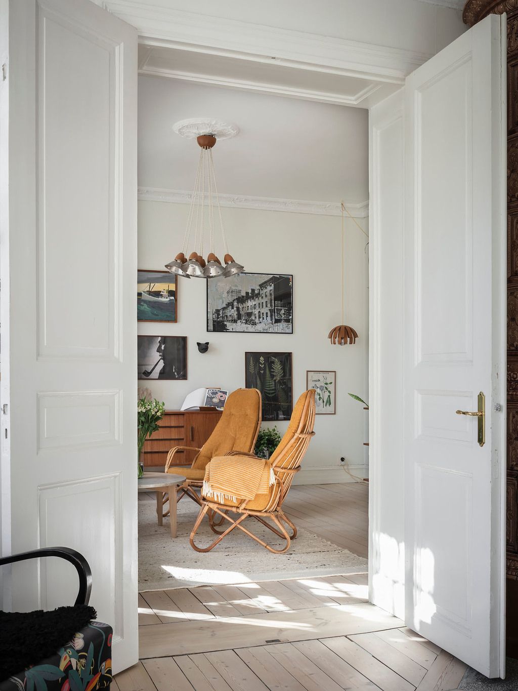 Valoisa olohuone täynnä kauniita retrokalusteita ja taidetta